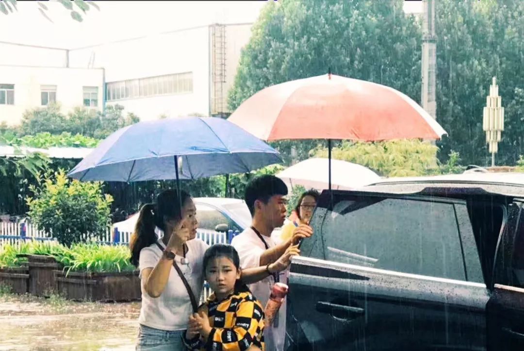 孩子雨中坚持演出，老师打伞守护背后的故事